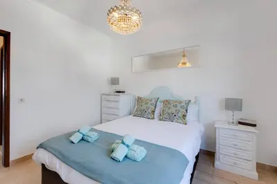 a bedroom with a bed with blue towels on it at ELI FLAT just few steps from the Strip in Albufeira in Albufeira