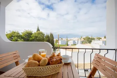 a basket of bread sitting on a table on a balcony at ELI FLAT just few steps from the Strip in Albufeira in Albufeira