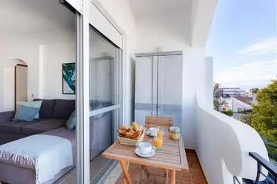 a small balcony with a table and a couch at ELI FLAT just few steps from the Strip in Albufeira in Albufeira