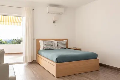 a bedroom with a bed and a large window at Estúdio 24 em Santa Bárbara de Nexe - Faro in Colmeal