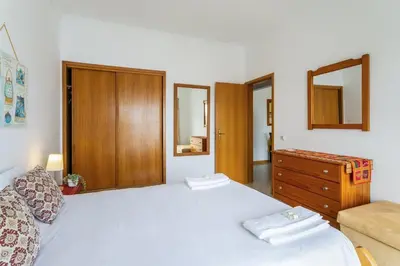 a bedroom with a large white bed and a dresser at TAC - Cerro Belo in Albufeira