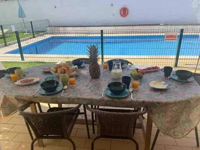 a table with food and fruit on it with a pool at Luxury Villa private pool, Albufeira in Albufeira