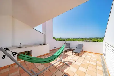 a hammock in the living room of a house at 3 bedroom Vila Sol Golf Resort- 1st Floor in Quarteira