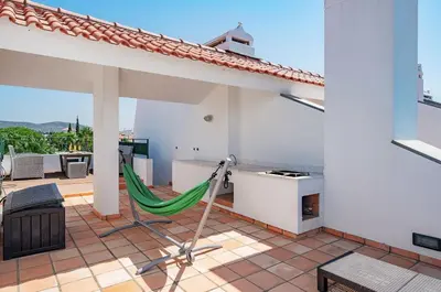 a hammock on the patio of a house at 3 bedroom Vila Sol Golf Resort- 1st Floor in Quarteira