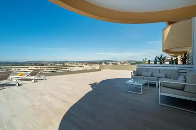 a patio with couches and chairs on a roof at Marina Mar Bela Vista by SAPvillas in Vilamoura