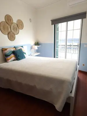 a bedroom with a large bed and a large window at Vivenda das Conchas - Just 50 Meters from the Beach in Quarteira