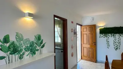 a hallway with a kitchen with a plant mural on the wall at Casa Vela São Rafael in Albufeira