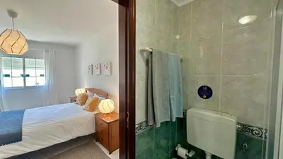a bedroom with a bed and a shower and a tub at Casa Vela São Rafael in Albufeira