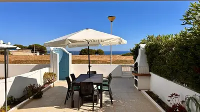 a table and chairs under an umbrella on a patio at Casa Vela São Rafael in Albufeira