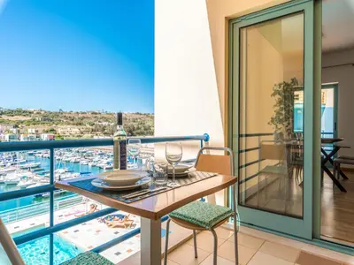 a balcony with a table and a view of a harbor at Luxury 1 Bedroom Apartment, Marina de Albufeira4 in Albufeira