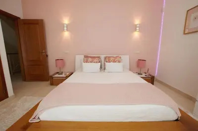 a bedroom with a large white bed with two lamps at Villa Perla in Guia