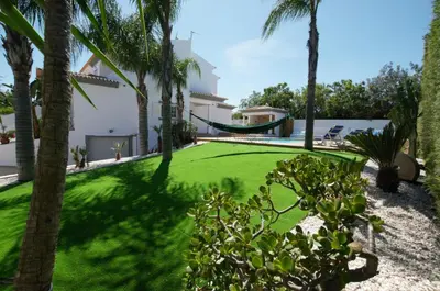a yard with palm trees and a hammock at Villa Perla in Guia