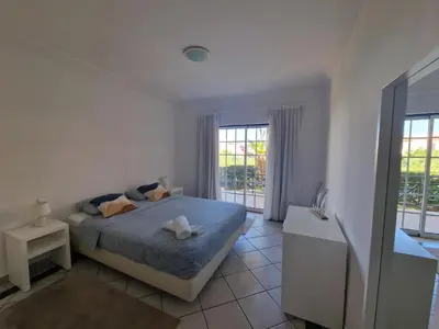a white bedroom with a bed and a window at Charming Villa Albufeira in Albufeira