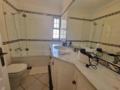 a bathroom with a sink and a tub and a mirror at Charming Villa Albufeira in Albufeira