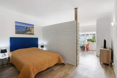a bedroom with a large bed and a living room at Sun and Serenity in Albufeira