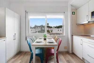 a kitchen with a table with chairs and a window at Sun and Serenity in Albufeira