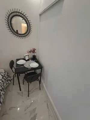 a dining room with a table and a mirror at Albufeira studio in Albufeira