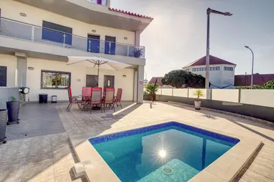 a backyard with a swimming pool and a house at Modern Vacation Home With Pool In Quarteira in Quarteira