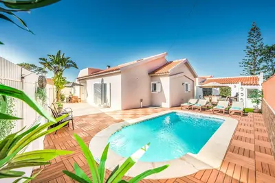 a villa with a swimming pool in front of a house at Casa Alfazema in Albufeira