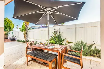 a table and chairs with an umbrella on a patio at Casa Alfazema in Albufeira