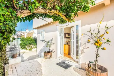 a white house with trees in front of it at Casa Alfazema in Albufeira