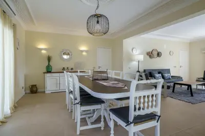 a dining room and living room with a table and chairs at Villa Lucio by SAPvillas in Vilamoura