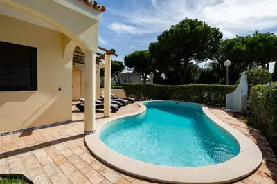 a swimming pool in a yard with a house at Villa Lucio by SAPvillas in Vilamoura