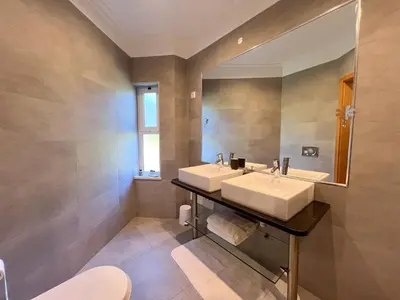 a bathroom with two sinks and a mirror at Beautiful 4-Bedroom Villa with Garden and Pool in Albufeira