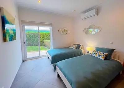 two beds in a room with a window at Beautiful 4-Bedroom Villa with Garden and Pool in Albufeira