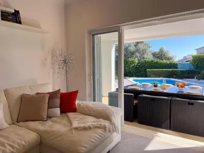 a living room with a couch and a sliding glass door at Beautiful 4-Bedroom Villa with Garden and Pool in Albufeira