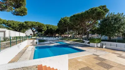 a swimming pool with trees in the background at Açoteias Studio w Pool by LovelyStay in Albufeira
