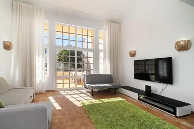 a living room with a flat screen tv and a couch at Ponta Grande Resort - Villa Dourada in Albufeira