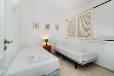 a bedroom with a bed and a desk and a window at Ponta Grande Resort - Villa Ponta in Albufeira