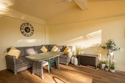 a living room with a couch and a table and a clock at Villa Louanna in Vilamoura