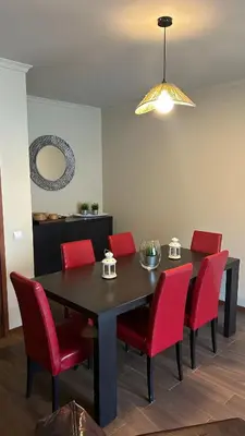 a dining room with a black table and red chairs at Pórtico de Malpique in Albufeira