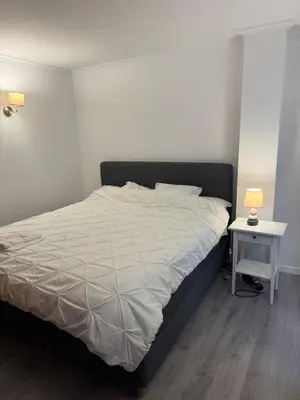 a bedroom with a bed and a table with a lamp at Casa Estrelinha Vilamoura in Quarteira