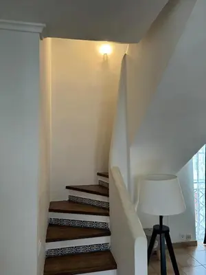 a staircase in a house with a lamp and a table at Casa Estrelinha Vilamoura in Quarteira
