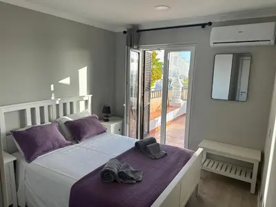 a bedroom with a bed with two shoes on it at Cliff Enchantment - Pool and Sea View in Albufeira in Albufeira