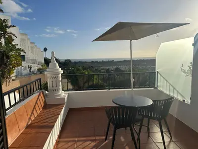 a balcony with a table and chairs and an umbrella at Cliff Enchantment - Pool and Sea View in Albufeira in Albufeira