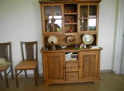 a wooden cabinet in a room with a table and chairs at Windmill Hill Luxury Apartment in Albufeira