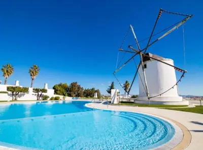 a windmill next to a swimming pool at Windmill Hill Luxury Apartment in Albufeira