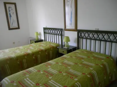 a bedroom with two beds with green comforter at Windmill Hill Luxury Apartment in Albufeira