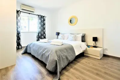 a white bedroom with a large bed and a window at Vale do Lobo Apartment in Vale do Lobo
