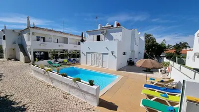 a white house with a swimming pool and chairs at Villa Gabriel by Sunny Deluxe in Albufeira