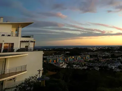 a building with a view of a city at sunset at Azure Heaven by BeCherish in Páteo