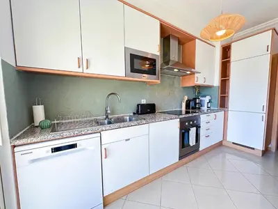 a kitchen with white cabinets and a sink at Azure Heaven by BeCherish in Páteo