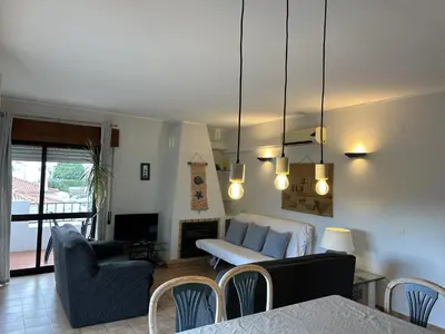 a living room with a table and chairs and a living room at Apartamento A11 - 800m da praia in Albufeira