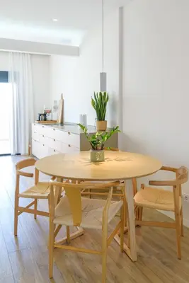 a dining room table and chairs with a plant on it at Beach front right on the Sand Luxury semi-detached 3 bed Villa in Faro