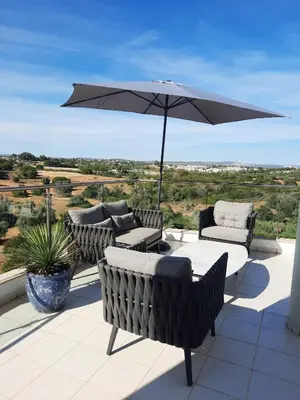 a patio with an umbrella and chairs and a table at Penthouse Monte da Eira - Sunset in Albufeira