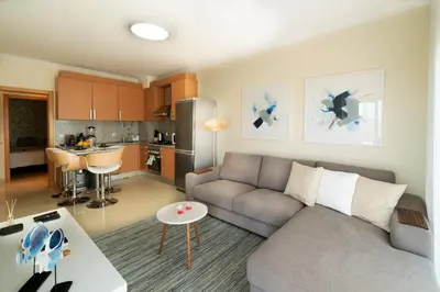 a living room with a couch and a kitchen at Penthouse Monte da Eira - Sunset in Albufeira